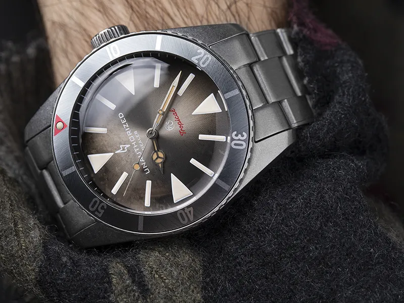 Montre en acier portée au poignet sur un pull en laine